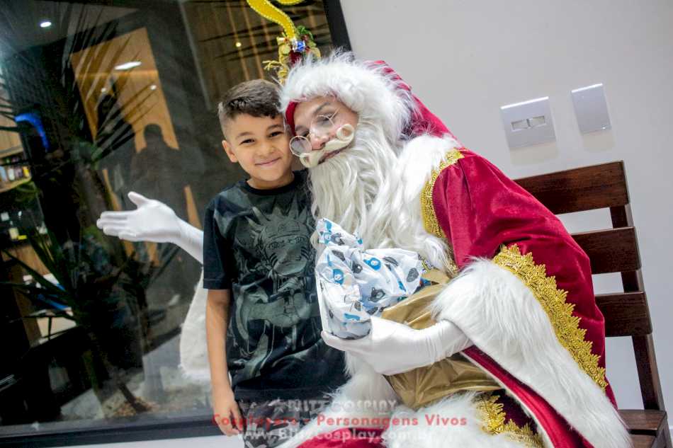 Papai Noel e criança posando para foto em Alphaville