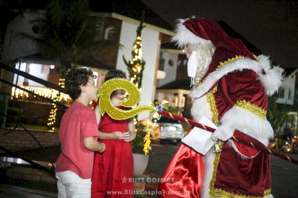 Papai Noel e criança posando para foto em Mauá